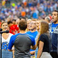 A group of gvsu choir students singing the national anthem to start the tigers game